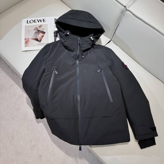 Moncler 2024Ss 新款 抽绳风帽logo冲锋羽绒服，男女同款，以黑色为主色调，兼具时尚与实用性。这款羽绒夹克采用黑色外套设计，简约而不失大气。其独特